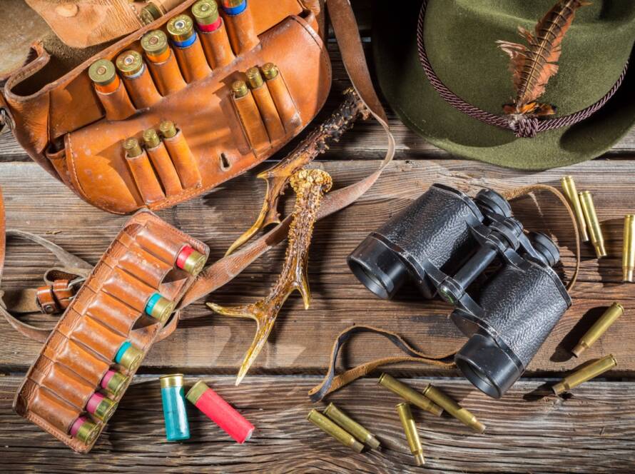 Various types of ammunition for hunting displayed on a wooden table.