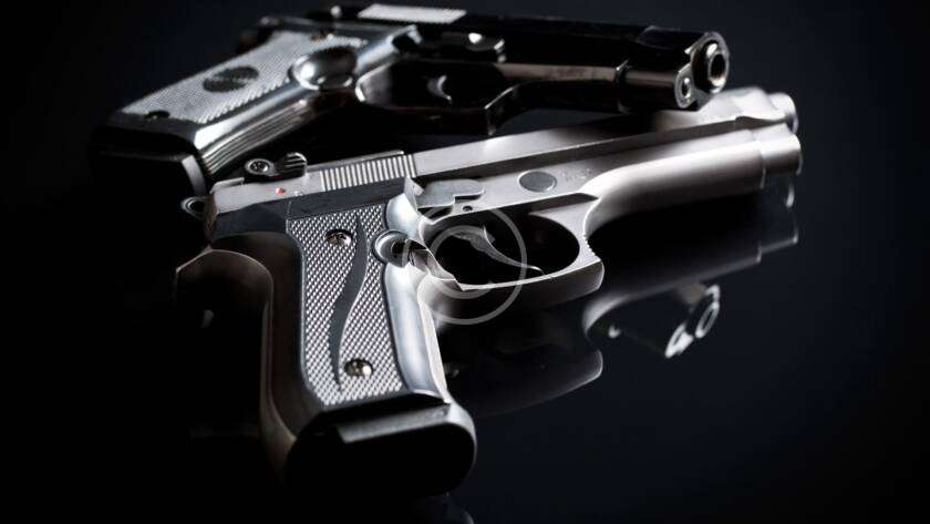 A beginner handling a handgun at a shooting range.