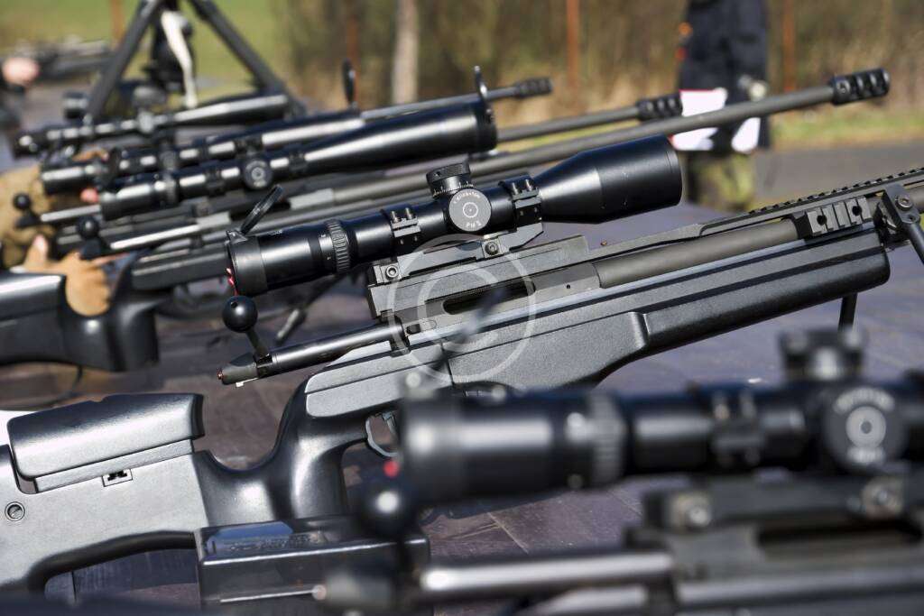 Shooter practicing long-range precision aiming with a rifle.