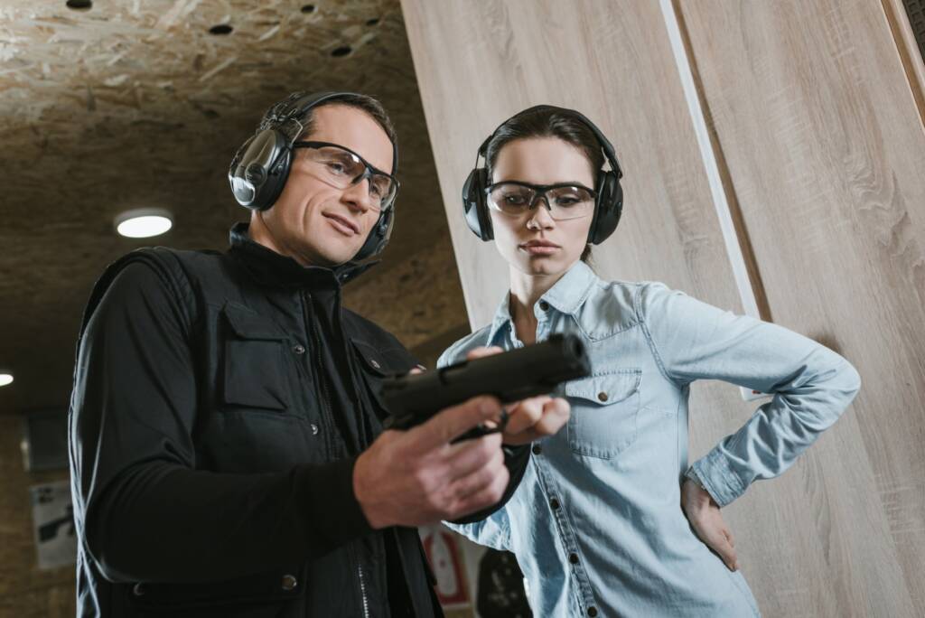 A beginner practicing safe handgun operation at a shooting range.