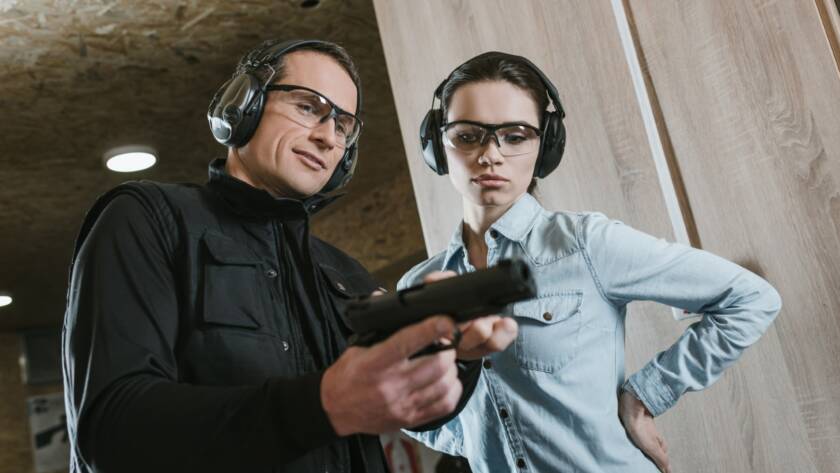 A beginner practicing safe handgun operation at a shooting range.